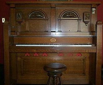 The Coinola X orchestrion with visible piano keys, pipes, and orchestra bells